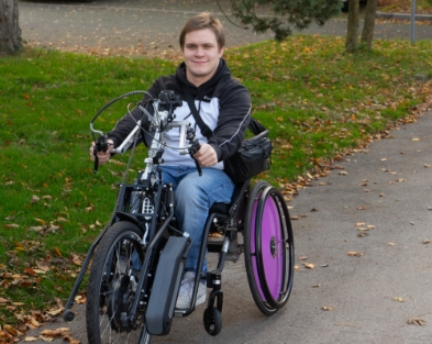 Person auf einem Elektro-Handbike – Einrichtung von Ladestationen für elektrische Mobilitätshilfen